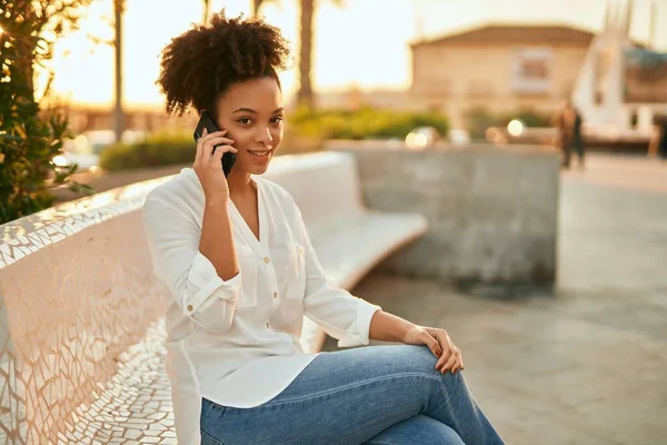 Ung Afrikansk Amerikansk Affärskvinna Ler Glad Prata Smartphone Sitter Bänken — Stockfoto