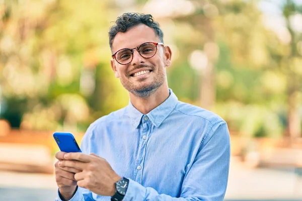Νεαρός Ισπανός Επιχειρηματίας Χαμογελώντας Χαρούμενος Χρησιμοποιώντας Smartphone Στην Πόλη — Φωτογραφία Αρχείου