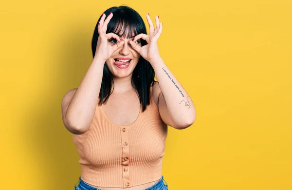 Young Hispanic Size Woman Wearing Casual Clothes Doing Gesture Binoculars — Stock Photo, Image