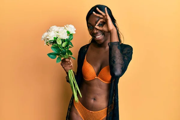 Νεαρή Αφροαμερικάνα Γυναίκα Φορώντας Εσώρουχα Κρατώντας Λουλούδια Χαμογελώντας Ευτυχισμένη Κάνει — Φωτογραφία Αρχείου