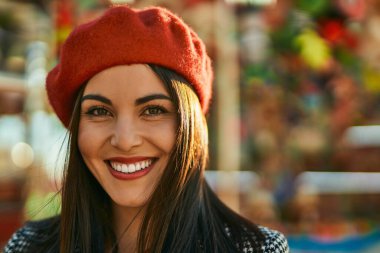 Genç İspanyol kadın gülümseyerek şehirde mutlu mesut dikiliyor..