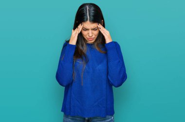 Genç İspanyol kadın stres yüzünden elleri başının üstünde gündelik giysiler giyiyor. migren ağrısı. 