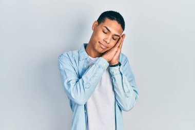 Genç Afro-Amerikalı, günlük kıyafetler giyip uyuyordu. Yorgundu, hayal kuruyordu ve elleriyle poz veriyordu. Gözleri kapalıydı.. 