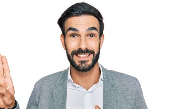 İş kıyafetleri giymiş, gülümseyen, elleri göğsünde ve parmakları havada küfür eden, sadakat yemini eden genç İspanyol bir adam. 