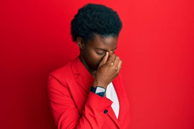 Genç Afro-Amerikan kız iş kıyafetleri giyip yorgun burnu ve gözleri ovuşturup yorgun ve baş ağrısı çekiyor. Stres ve hüsran kavramı. 