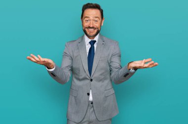 Orta yaşlı bir adam iş kıyafetleri içinde neşeli bir şekilde gülümsüyor yardım eli uzatıyor ve kabul ediyor.. 