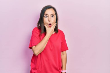 Orta yaşlı İspanyol kadın sıradan kıyafetler giyiyor. İnançsızlığa, şaşkınlığa ve elleri çenesinde olan şaşkınlık ifadesine hayran görünüyor. 