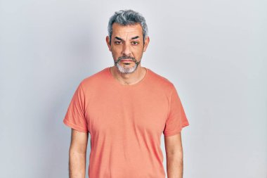 Gri saçlı, depresif tişörtlü, sıkıntılı, sinirli ve korkmuş, orta yaşlı yakışıklı bir adam. hüzünlü ifade. 