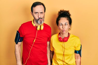 Orta yaşlı bir çift İspanyol kadın ve erkek spor giyer ve kol bandı takar dudaklarıyla balık yüzü yapar, çılgınca ve komik bir jest. Komik ifade. 