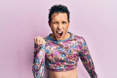 Yakışıklı adam makyaj yapıyor, kızgın ve kızgın. Öfkeyle bağırırken yumruğunu kaldırıyor. öfke ve agresif konsept. 