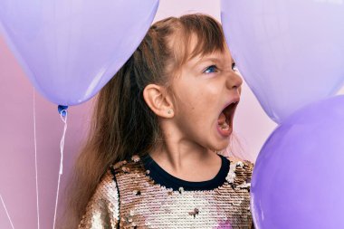 Kafkasyalı küçük kız elinde kızgın ve kızgın balonlar tutuyordu. Öfkeli ve öfkeliydi. Öfkeyle bağırıyordu. öfke ve agresif konsept. 