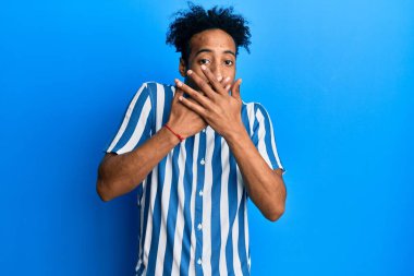 Sıradan çizgili gömlek giyen, sakallı, Afro-Amerikalı genç bir adam ağzını yanlışlıkla ellerle kapatarak şok etti. gizli kavram. 