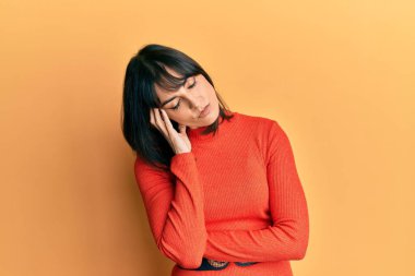 Gündelik kıyafetler giyen genç İspanyol kadın kollarını kavuşturarak depresyondan sıkılmış ve yorgun görünüyor.. 