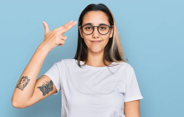 Latin kökenli genç bir kadın, günlük beyaz tişörtler giyip kendini vuruyor ve öldürüyor. Elini ve parmaklarını silah gibi kullanıyor. İntihar hareketi.. 