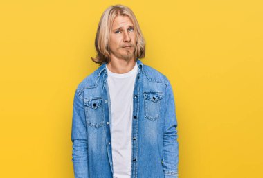 Sarışın, uzun saçlı, sıradan bir kot ceket giyen, kuşkucu ve gergin beyaz bir adam. Sorunları yüzünden surat asıyor. negatif kişi. 