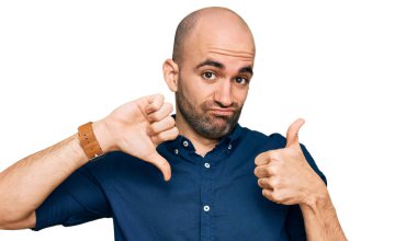 Latin asıllı genç bir adam günlük kıyafetler giyip baş parmak kaldırıyor, anlaşmazlık ve uzlaşma ifadesi. çılgın çatışma 