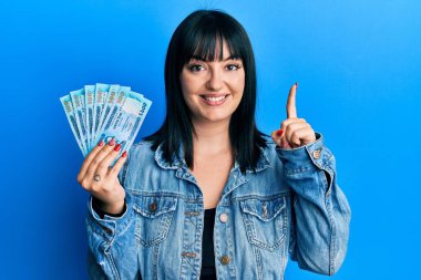 Bangladeş 'i elinde tutan genç İspanyol kadın bir fikir veya soruyla gülümseyen bir banknot tutuyor. 