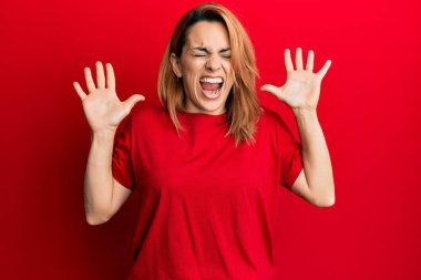 Gündelik kırmızı tişört giyen İspanyol genç bir kadın başarının çılgınlığını kutluyor. Kollarını kaldırmış, gözlerini kapatmış heyecanla bağırıyor. Kazanan konsept 