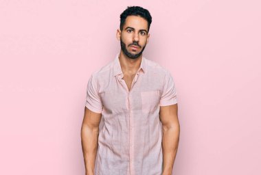 Sakallı, sıradan tişörtlü, komik yüzlü İspanyol bir adam. Havayla şişmiş ağız, çılgın bir ifade.. 