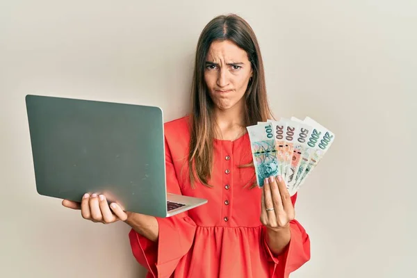 Young Beautiful Woman Holding Laptop Czech Koruna Banknotes Skeptic Nervous — Stock Photo, Image