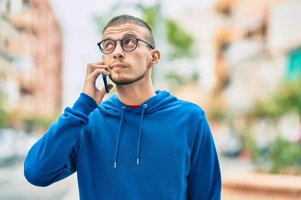 Joven Hombre Hispano Con Expresión Relajada Hablando Smartphone Ciudad —  Fotos de Stock