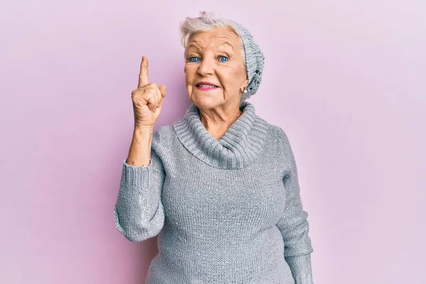 Eine Ältere Grauhaarige Frau Wollpullover Und Wintermütze Zeigt Mit Erhobenem — Stockfoto