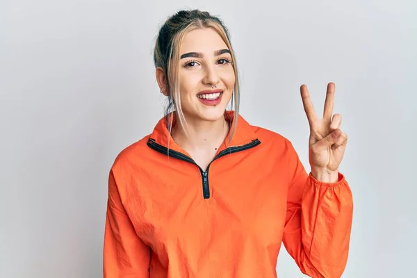 Ung Moderne Pige Iført Sports Sweatshirt Viser Peger Med Fingrene - Stock-foto