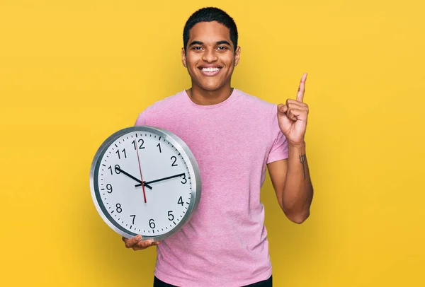 Ung Stilig Latinamerikansk Man Håller Stor Klocka Förvånad Med Idé — Stockfoto