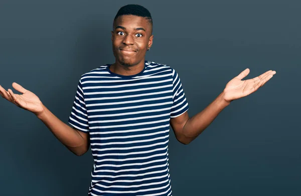 Joven Hombre Afroamericano Vistiendo Casual Rayas Camiseta Despistado Confundido Con — Foto de Stock