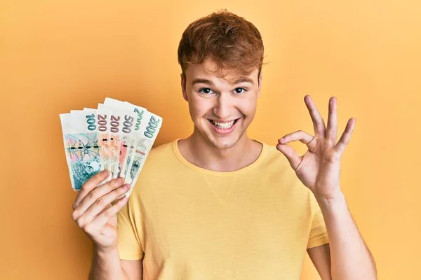Młody Biały Mężczyzna Noszący Okulary Czeskimi Banknotami Korony Robi Znak — Zdjęcie stockowe
