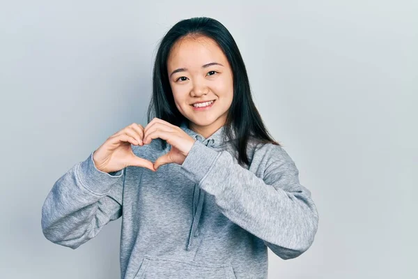 Young Chinese Girl Wearing Casual Clothes Smiling Love Showing Heart — Stock Photo, Image