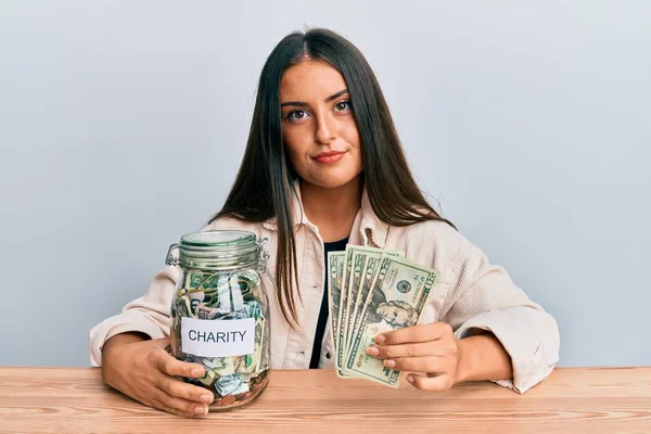 Krásná Hispánka Držící Ruce Charitativní Sklenici Dolary Uvolněná Vážným Výrazem — Stock fotografie