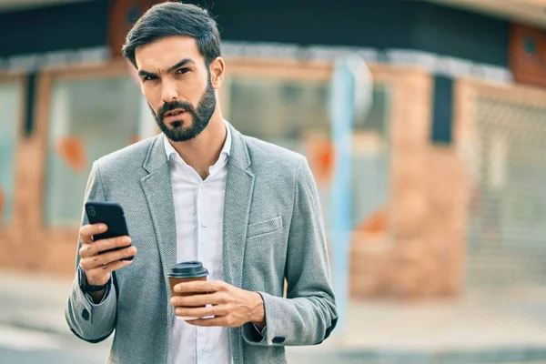 Jonge Spaanse Zakenman Met Serieuze Expressie Met Smartphone Het Drinken — Stockfoto