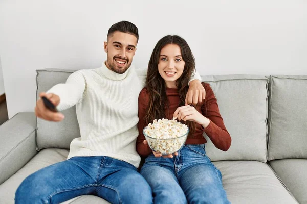 Young Hispanic Couple Watching Film Eating Popcorn Sitting Sofa Home — Stock Photo, Image