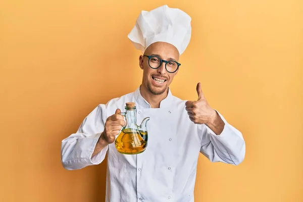 Καραφλός Άνθρωπος Γενειάδα Φορώντας Επαγγελματική Ποδιά Μάγειρας Κρατώντας Ελαιόλαδο Χαμογελώντας — Φωτογραφία Αρχείου