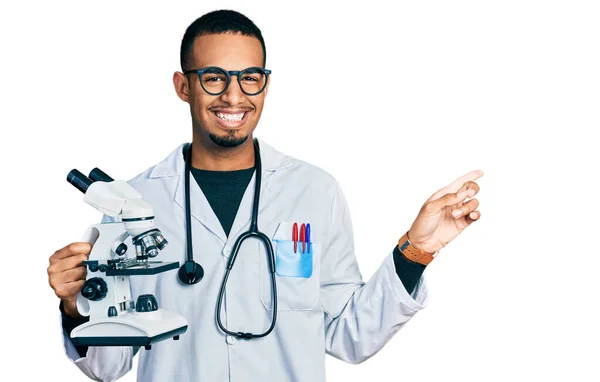 아프리카 미국인 과학자 유니폼을 손가락으로 가리키며 행복하게 미소짓고 — 스톡 사진