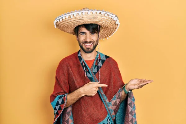 Jovem Hispânico Segurando Chapéu Mexicano Maravilhado Sorrindo Para Câmera Enquanto — Fotografia de Stock