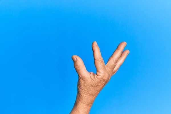 Mano Dell Uomo Ispanico Anziano Sfondo Blu Isolato Raccogliendo Prendendo — Foto Stock