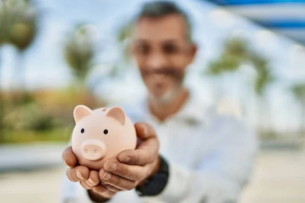 Středního Věku Šedovlasý Muž Usměvavý Šťastný Držení Prasátko Banky Městě — Stock fotografie
