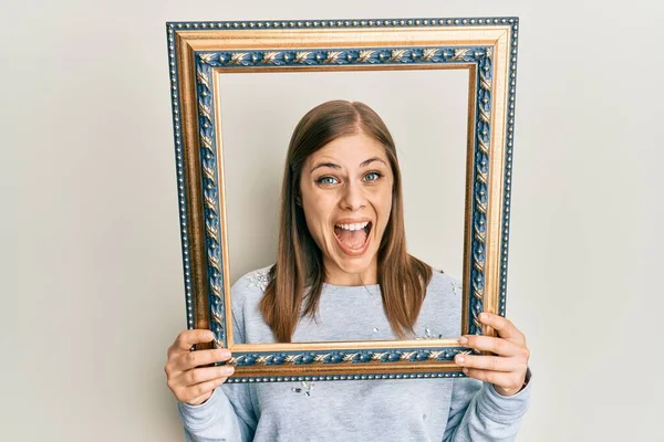 Mooie Kaukasische Vrouw Houden Leeg Frame Vieren Gek Verbaasd Voor — Stockfoto