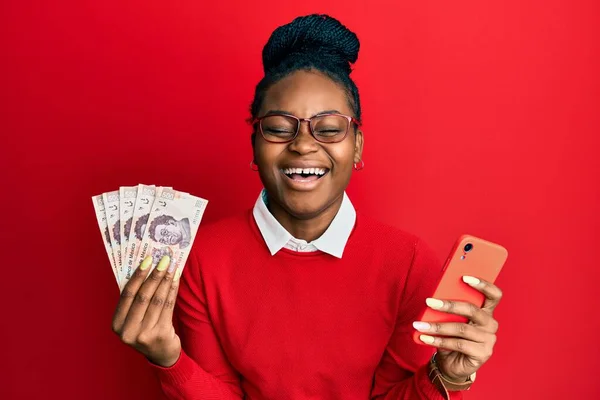 Joven Mujer Afroamericana Usando Teléfono Inteligente Sosteniendo Billetes Peso Mexicano —  Fotos de Stock