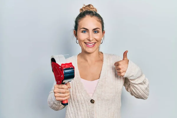 Mulher Branca Jovem Segurando Máquina Fita Adesiva Sorrindo Feliz Positivo — Fotografia de Stock