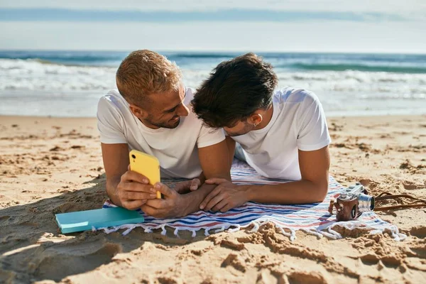 Νεαρό Ομοφυλόφιλο Ζευγάρι Που Χρησιμοποιεί Smartphone Ξαπλωμένο Στην Άμμο Στην — Φωτογραφία Αρχείου