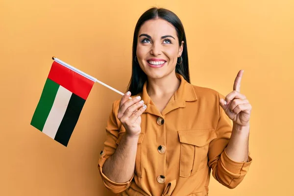 Νεαρή Μελαχρινή Γυναίκα Που Κρατά Ενωμένη Την Αραβική Σημαία Χαμογελώντας — Φωτογραφία Αρχείου