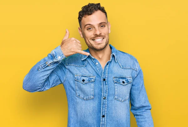 Junger Hispanischer Mann Lässiger Jeansjacke Lächelt Und Macht Telefongesten Mit — Stockfoto