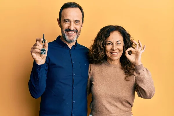 Medelålders Latinamerikanska Par Håller Nycklar Till Nya Hem Gör Tecken — Stockfoto