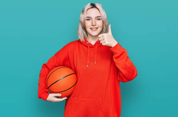 Menina Loira Jovem Segurando Bola Basquete Sorrindo Feliz Positivo Polegar — Fotografia de Stock