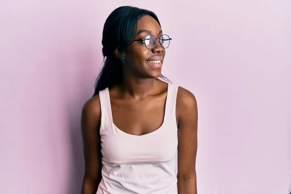 年轻的非洲裔美国女人 身穿休闲装 戴着眼镜 面带微笑 放松自己的形象 — 图库照片