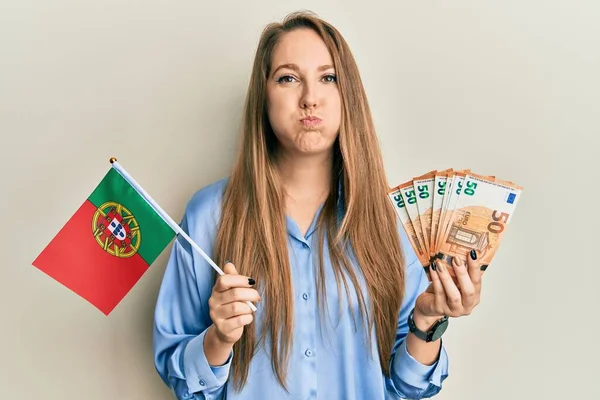 Jovem Loira Segurando Bandeira Portugal Notas Euros Soprando Bochechas Com — Fotografia de Stock