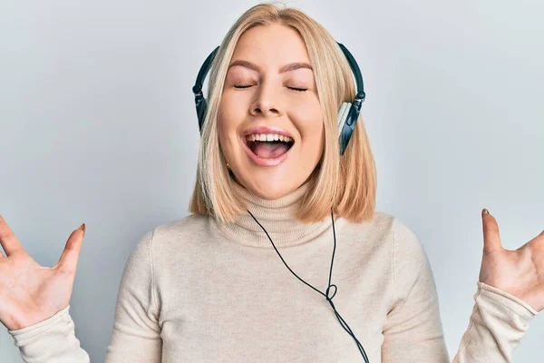 Young Blonde Woman Listening Music Using Headphones Celebrating Mad Crazy — Stock Photo, Image